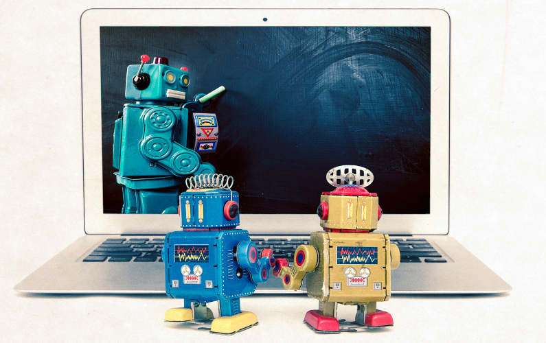 Image of little machines that look like robots that are in front of another machine that looks like a robot that is teaching machine learning on a computer